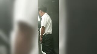 A male is pissing in the toilet.