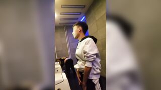 A male is pissing in the toilet.
