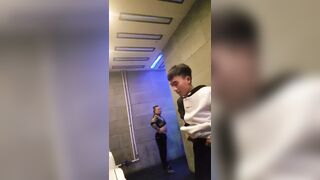 A male is pissing in the toilet.