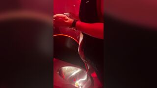 A male is pissing in the toilet.