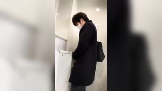 A male is pissing in the toilet.