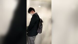 A male student is pissing in the toilet.