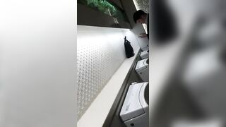 A male is pissing in the toilet.