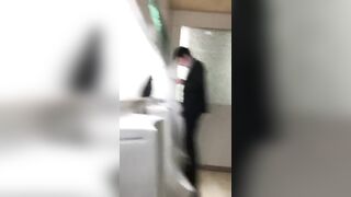 A male is pissing in the toilet.