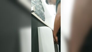 A male is pissing in the toilet.