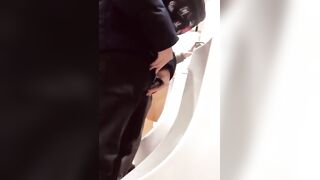A male is pissing in the toilet.