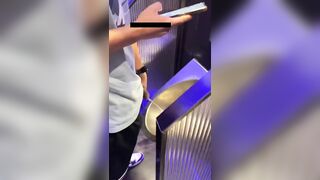 A male is pissing in the toilet.