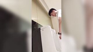 A male is pissing in the toilet.