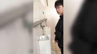A male student is pissing in the toilet 3