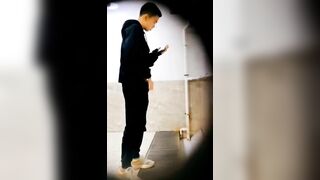 A male student is pissing in the toilet.