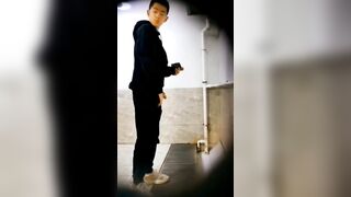 A male student is pissing in the toilet.
