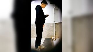 A male student is pissing in the toilet.