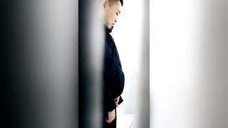 A male is pissing in the toilet.