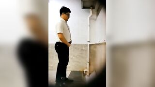 A male is pissing in the toilet.