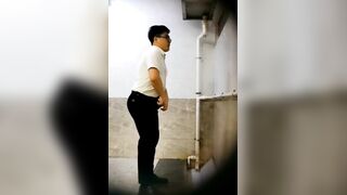 A male is pissing in the toilet.