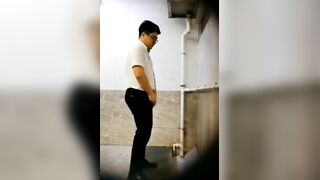 A male is pissing in the toilet.