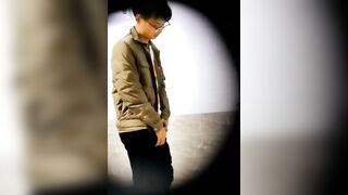 A male is pissing in the toilet.
