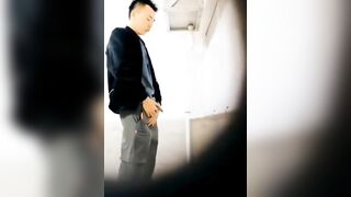 A male is pissing in the toilet.