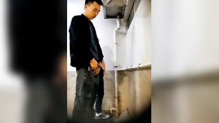 A male is pissing in the toilet.