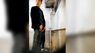 A male is pissing in the toilet.