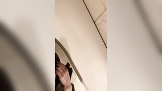 A male is pissing in the toilet.