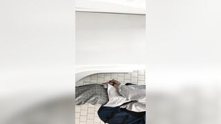 A male is pissing in the toilet.