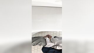 A male is pissing in the toilet.
