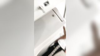 A male is pissing in the toilet.
