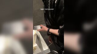 A male is pissing in the toilet.