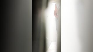 A male is pissing in the toilet.
