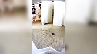 A male student is pissing in the toilet.
