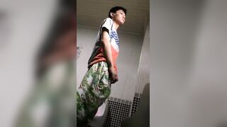 A male is pissing in the toilet.