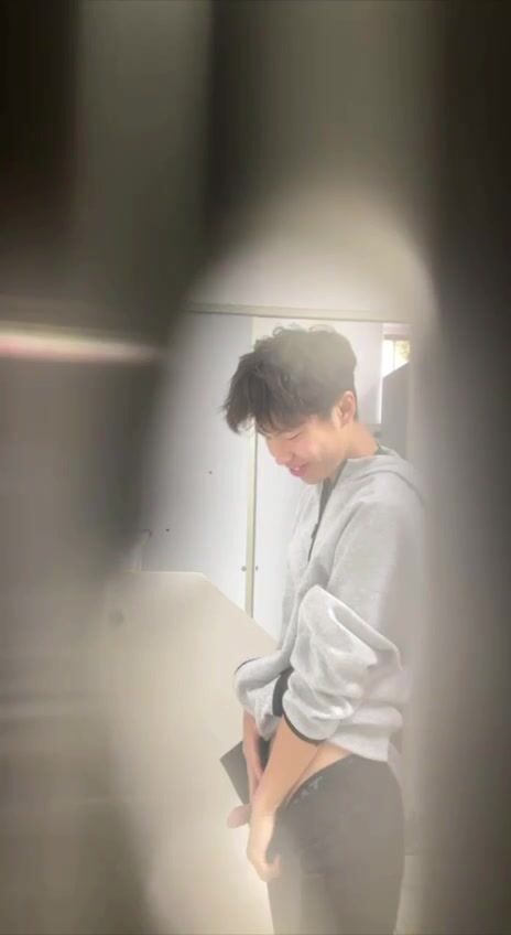 A male student is pissing in the toilet.